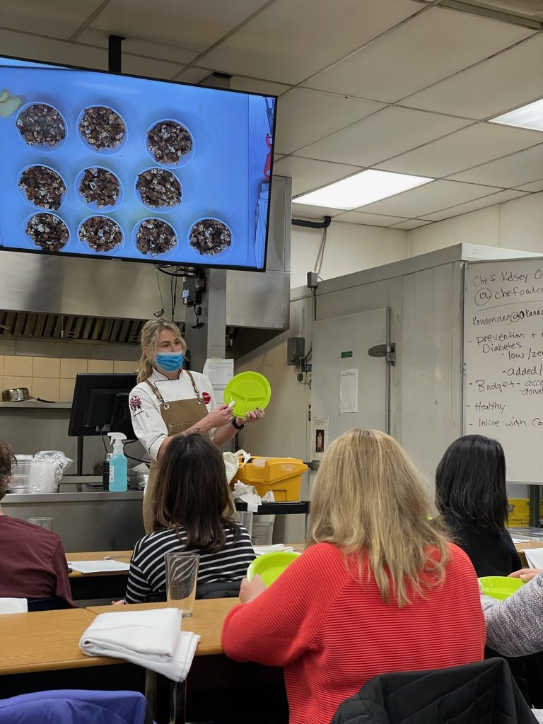 Chef Kelsey demonstrating portion plates at cooking class